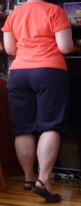 Me, from the back, wearing navy plus fours (knickerbockers) and a coral tee.